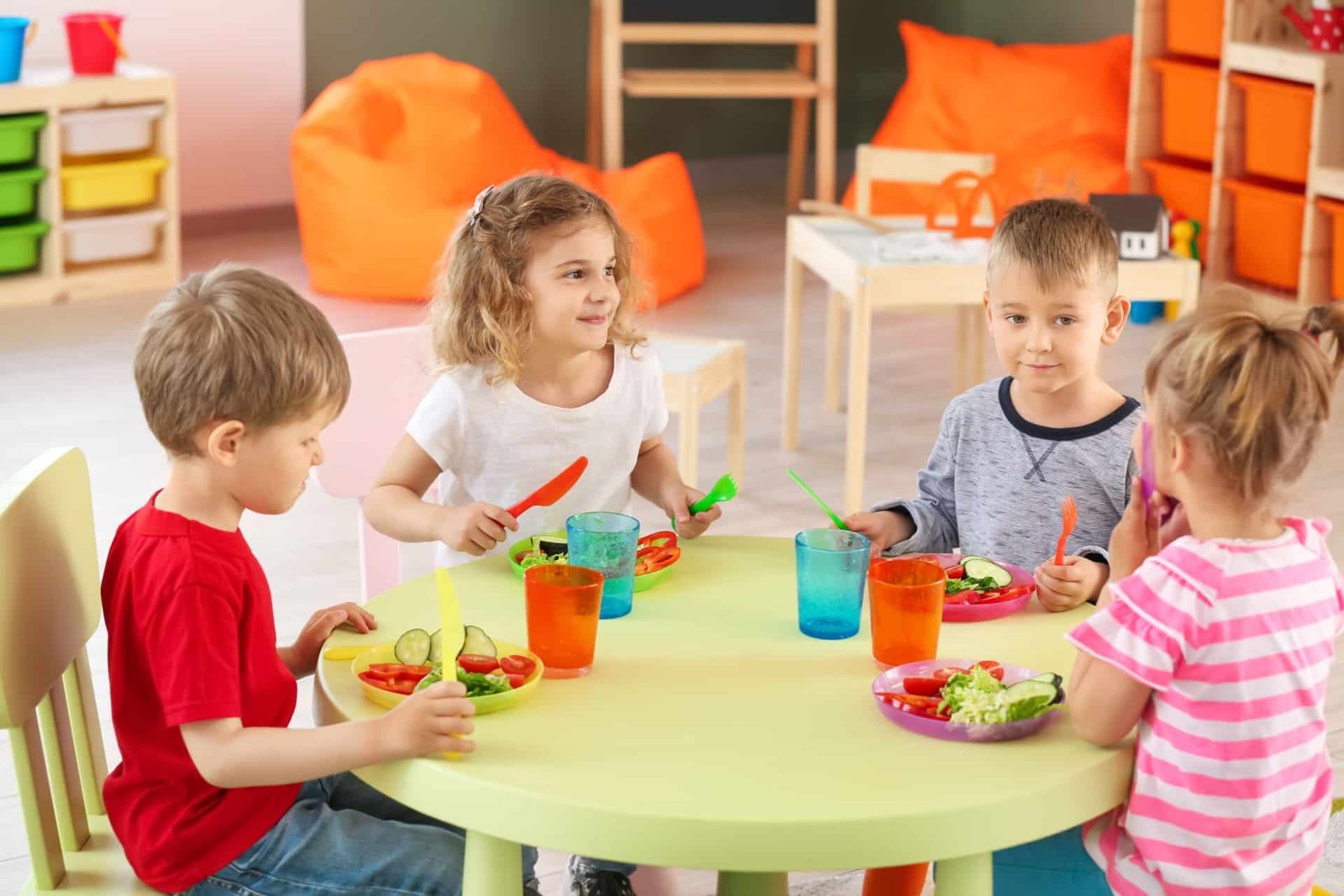 Children sharing a healthy lunch of salads and vegetables at daycare